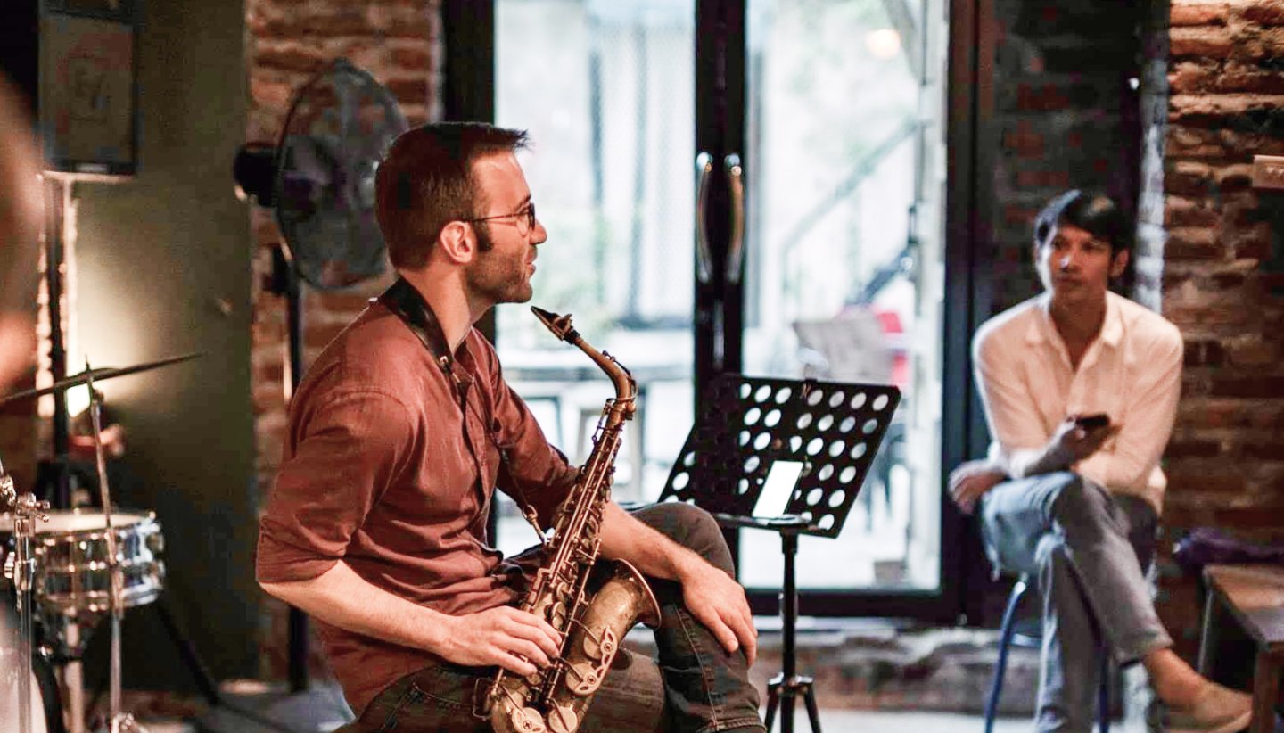Online saxophone lesson scene with student and teacher on video call